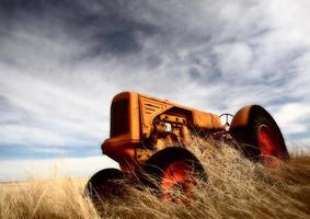 tumbleweeds empilés contre un tracteur abandonné photo