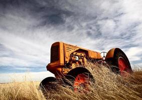 tumbleweeds empilés contre un tracteur abandonné photo