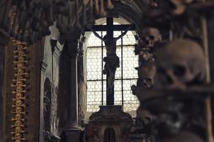 Kutna hora, république tchèque, 14 mai 2019 crucifixion de jésus christ dans la fenêtre et gros plan de crâne humain flou photo