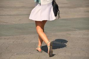 femme en robe blanche avec des sandales dans la ville photo