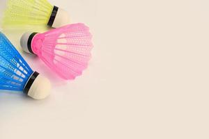 trois volants de badminton multicolores sur fond blanc. photo