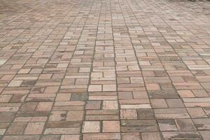 vue en perspective de la chaussée en pierre de brique au sol pour la route de la rue. texture de motif carré de rez-de-chaussée vintage pour maquette. photo