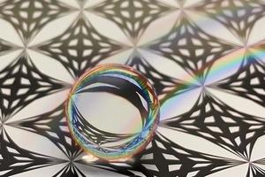 reflet d'un motif géométrique et abstrait dans une sphère de verre avec effet de couleurs arc-en-ciel. photo