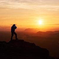photographe de nature avec appareil photo numérique au sommet de la montagne.