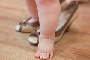 petit bébé bébé jouant adulte dans les chaussures à talons de la mère photo