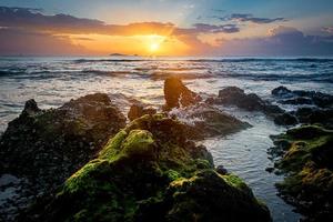paysage coucher de soleil sur la plage rochers au premier plan photo