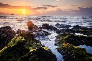 paysage coucher de soleil sur la plage rochers au premier plan photo