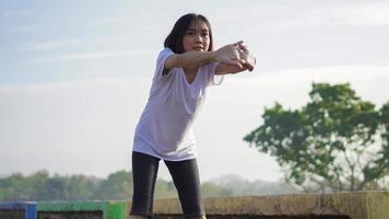 une jeune femme asiatique s'étire avant de faire du jogging et de courir le matin photo