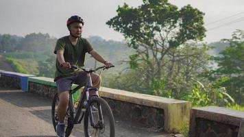 jeune homme asiatique faire du vélo le matin photo