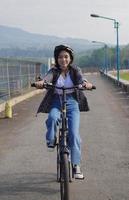 jeune femme asiatique faire du vélo pour travailler, elle est heureuse et en sécurité photo