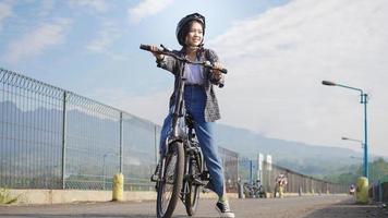 jeune femme asiatique faire du vélo avant d'aller travailler photo