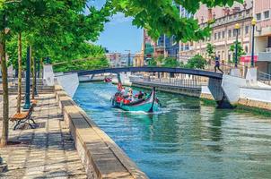 aveiro, portugal, 13 juin 2017 paysage urbain aveiro avec bateau moliceiro coloré traditionnel avec touristes naviguant dans un canal d'eau étroit photo