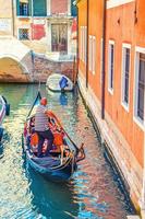 Venise, Italie, 13 septembre 2019 gondolier sur gondole avec des touristes naviguant dans un canal d'eau étroit à Venise photo