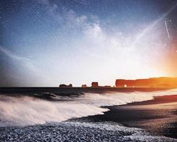 les orteils du rock troll. falaises de reynisdrangar. plage de sable noir. Islande. fantastique ciel étoilé et la voie lactée photo