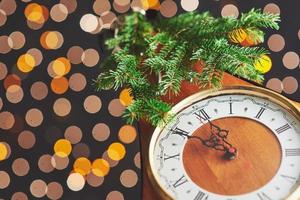 bonne année à minuit 2018, vieille horloge en bois avec lumières de Noël et branches de sapin photo