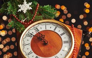 bonne année à minuit 2018, vieille horloge en bois avec lumières de Noël et branches de sapin photo