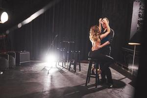 danseurs habiles se produisant dans la pièce sombre sous la lumière photo