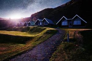 une petite église en bois et un cimetière hofskirkja hof, skaftafell islande. coucher de soleil pittoresque à travers les cimes des arbres photo