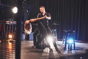 danseurs habiles se produisant dans la pièce sombre sous la lumière photo