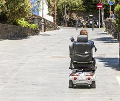 femme en fauteuil roulant électrique dans la rue photo