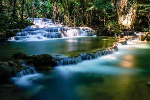 longue exposition exotique belle cascade de forêt tropicale profonde cascades turquoises fraîches dans la forêt profonde de la cascade de huay mae khamin dans le parc national de belles cascades de paysage. photo