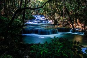 longue exposition exotique belle cascade de forêt tropicale profonde cascades turquoises fraîches dans la forêt profonde de la cascade de huay mae khamin dans le parc national de belles cascades de paysage. photo