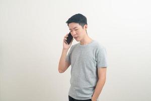 jeune homme asiatique utilisant ou parlant un smartphone et un téléphone portable photo