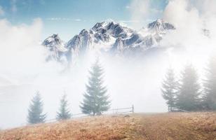 montagnes dans le brouillard. culmine sous de gros nuages. paysage d'automne silencieux. neige sur les collines photo