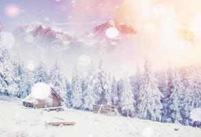cabane dans les montagnes en hiver, arrière-plan avec quelques reflets doux et flocons de neige. carpates, ukraine. photo
