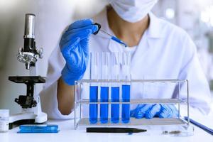 scientifiques faisant des recherches en laboratoire en blouse blanche, gants analysant, regardant un échantillon de tubes à essai, concept de biotechnologie photo