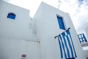 drapeau grec sur le mur de la maison traditionnelle blanche de grèce photo