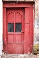porte en bois rouge avec verre dans un mur de bâtiment en béton vieilli photo