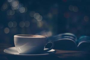 tasse de café avec magazine sur table au café dans des tons sombres et vintage photo