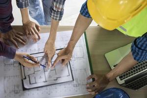 équipe d'ingénieurs planifiant et discutant de la construction d'un bâtiment sur une table dans un chantier