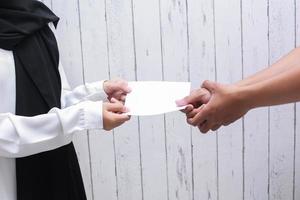 main tenant une enveloppe blanche pour donner ou payer la zakat fitrah comme une obligation pendant le mois sacré du ramadan photo