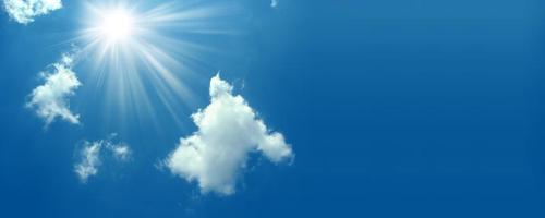 un ciel bleu avec fond de soleil et de nuages. soleil brillant sur ciel bleu avec nuages. fond de ciel ensoleillé. ciel bleu du matin, soleil brillant se levant et traversant les nuages blancs. le soleil brillant de midi photo