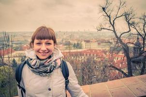 portrait en gros plan d'une jeune fille caucasienne voyageuse avec une veste blanche regardant la caméra et souriant