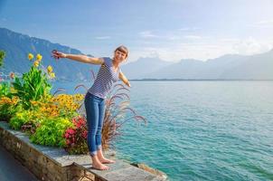 Jeune belle fille voyageur avec chemise rayée et jeans posant et sourire sur le quai du lac Léman Genève photo