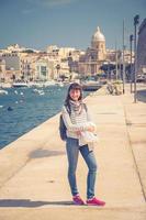 séjour de voyageur de jeune fille et posant sur le remblai du ruisseau kalkara du grand port de malte photo