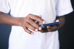 gros plan de la main du jeune homme à l'aide d'un téléphone intelligent. photo