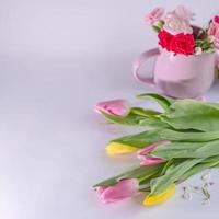 bouquet de tulipes jaunes et roses sur fond blanc. tasse avec des fleurs. fond de la saint-valentin et de la fête des mères. photo