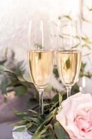 composition avec des verres de vigne et de fleurs sur fond de béton gris. photo