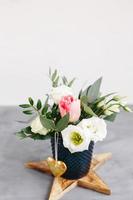 bouquet de printemps dans un vase en verre transparent sur une étoile en bois. roses, tulipes et lisianthus. photo