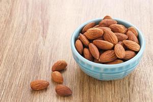 amandes dans un bol sur une table en bois. fermer. mise au point sélectionnée photo