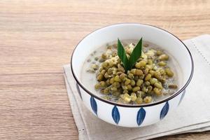 bouillie de haricots mungo ou bubur kacang hijau, bouillie dessert indonésienne de haricots mungo avec lait de coco, feuille de pandan et gingembre. servi dans un bol. photo