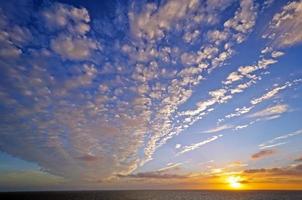 nuages dramatiques au coucher du soleil sur l'océan photo