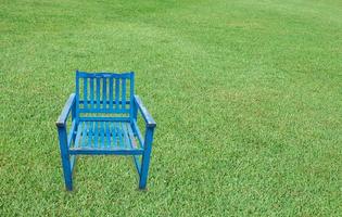 Chaise en bois bleu antique sur fond d'herbe verte photo