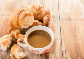 café et croissant pour le petit déjeuner sur table en bois photo