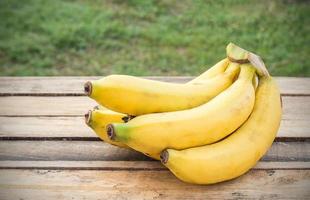 bananes fraîches sur fond de bois photo