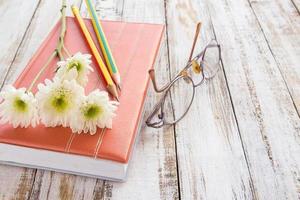 fleur blanche et crayon sur cahier sur table en bois
